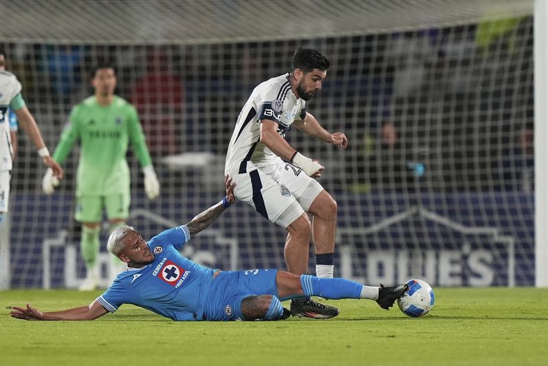 Brian White, de los Whitecaps de Vancouver, resiste la barrida de Gonzalo Piovi, del Cruz Azul, en la final de la Copa de Campeones de la CONCACAF, el domingo 1 de junio de 2025, en Ciudad de México (AP Foto/Fernando Llano)
