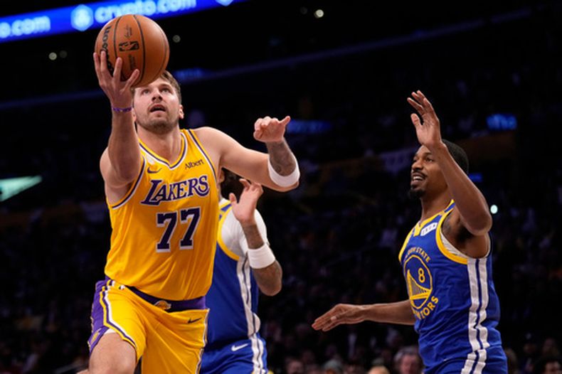 El base de los Lakers de Los Ángeles Luka Doncic lanza el balón frente al base de los Warriors de Golden State Deanthony Melton en el encuentro de la NBA del miércoles 21 de octubre del 2026. (AP Foto/Mark J. Terrill)