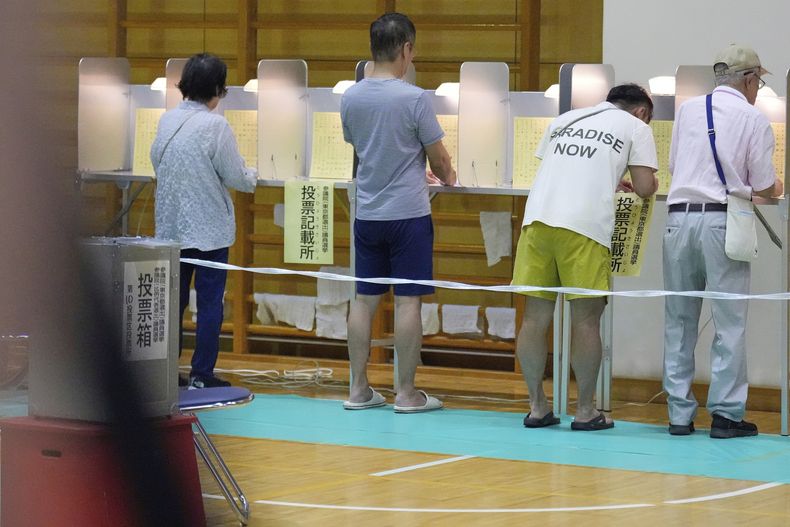 Votantes rellenan sus boletas durante las elecciones a la cámara alta de Japón, en un centro de votación en Tokio, el domingo 20 de julio de 2025. (AP Foto/Eugene Hoshiko)