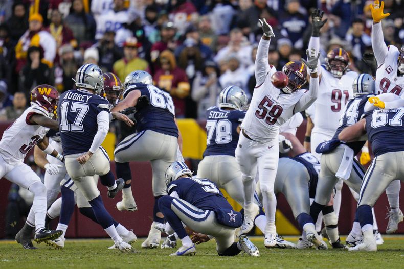 El defensive end de los Commanders de Washington Joshua Pryor (59) bloquea un gol de campo ejecutado por Brandon Aubrey (17) de los Cowboys de Dallas durante la primera mitad del juego de la NFL, el domingo 7 de enero de 2024, en Landover, Maryland. (AP Foto/Jessica Rapfogel)