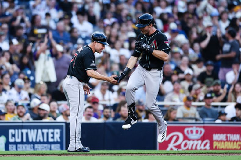 Max Kepler, derecha, de los Diamondbacks de Arizona, es felicitado por el coach de tercera base, J.R. House, izquierda, después de disparar un jonrón de tres carreras ante los Padres de San Diego, en la tercera entrada del juego de béisbol de Grandes Ligas, el lunes 6 de julio de 2026, en San Diego. (AP Foto/Derrick Tuskan)