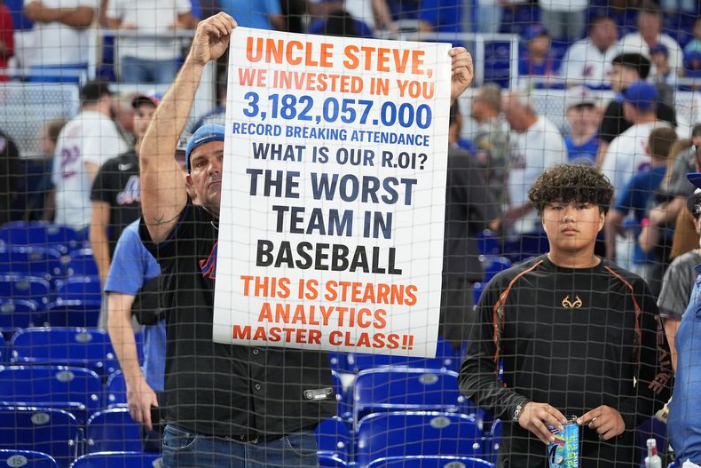Un aficionado sostiene un cartel que se refiere a los Mets de Nueva York tras la derrota 4-0 ante los Marlins de Miami, el domingo 28 de septiembre de 2025, en Miami. (AP Foto/Lynne Sladky)