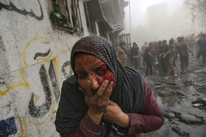 Una mujer palestina herida sale corriendo tras ataques aéreos israelíes sobre su vecindario en la Ciudad de Gaza, el 23 de octubre de 2023. (AP Foto/Abed Khaled)