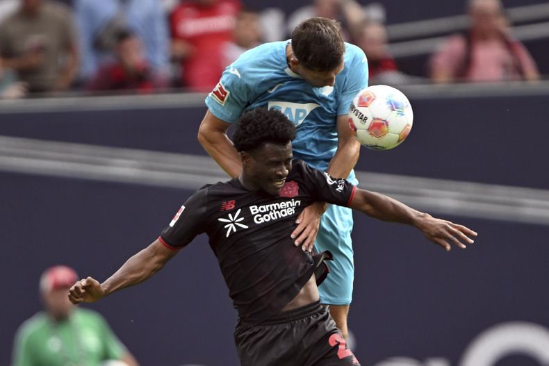 Robin Hranác del Hoffenheim y Nathan Tella del Bayer Leverkusen saltan por el balón en el encuentro de la Bundesliga el sábado 23 de agosto del 2025. (Federico Gambarini/dpa via AP)