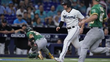 Nick Fortes (centro) de los Marlins de Miami anota una carrera ante los Atléticos de Oakland, el domingo 4 de junio de 2023, en Miami. (AP Foto/Wilfredo Lee)