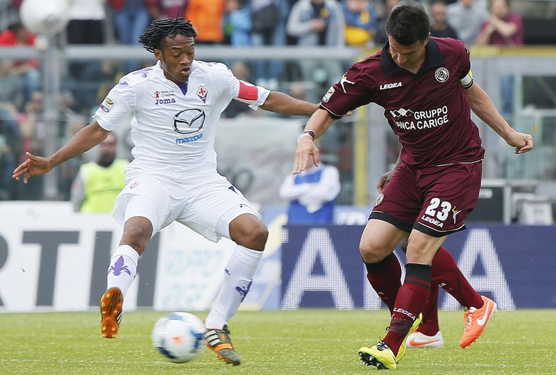 El jugador de la Fiorentina y la selecci&oacute;n colombiana, Juan Cuadrado, izquierda, disputa un bal&oacute;n en un partido contra Livorno por la Serie A el domingo, 11 de mayo de 2014, en Lehgorn, Italia. (AP Photo Fabio Muzzi )