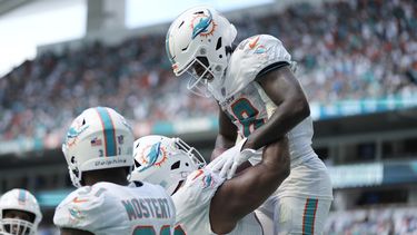 El defensive tackle Christian Wilkins (94), levanta a su compañero de los Dolphins de Miami DeVon Achane (28) después de que anotó un touchdown en la segunda mitad del partido ante los Broncos de Denver, el domingo 24 de septiembre de 2023, en Miami Gardens, Florida. (AP Foto/Rebecca Blackwell)
