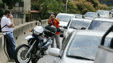Venezolanos acuden a una carretera para hablar por teléfono