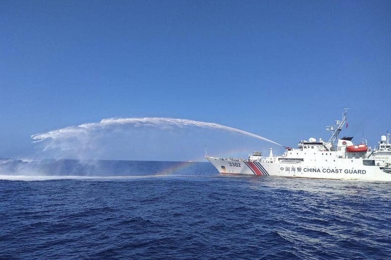 Un barco de la guardia costera china lanza agua contra un barco del Departamento de Pesca y Recursos Acuáticos de Filipinas, en el disputado Mar de China Meridional, el 9 de diciembre de 2023. Foto suministrada por la Guardia Costera de Filipinas. (Guardia Costera de Filipinas via AP)