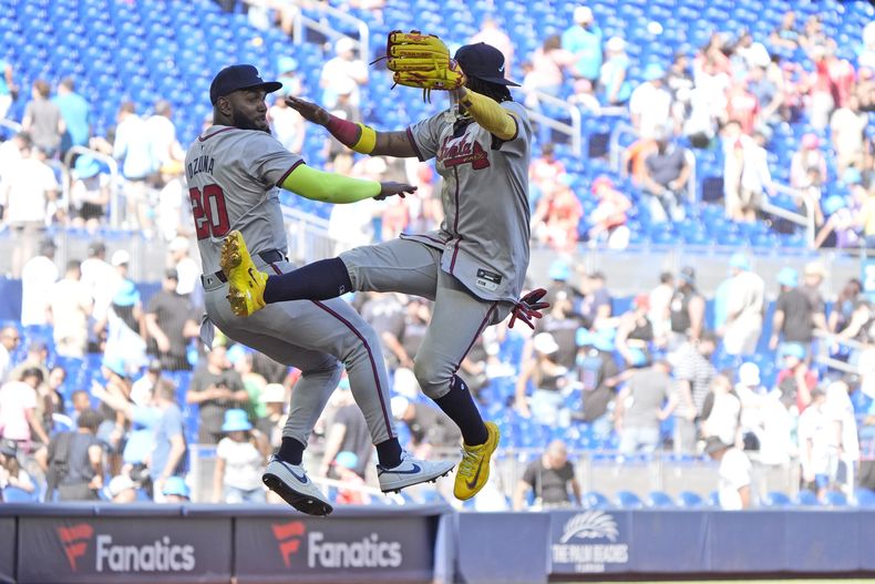 Marcell Ozuna (20), bateador designado de los Bravos de Atlanta, y el jardinero derecho Ronald Acuña Jr. delebran después de que su equipo derrotara 9-7 a los Marlins de Miami , en el juego de béisbol del domingo 14 de abril de 2024, en Miami. (AP Foto/Wilfredo Lee)