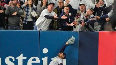 El jardinero izquierdo Víctor Mesa Jr. de los Rays de Tampa Bay trata de atrapar una pelota interferida por fanáticos tras el batazo de Anthony Volpe de los Yankees de Nueva York, en el sexto inning del tercer juego de la serie divisional de la Liga Americana, el miércoles 7 de octubre de 2026, en Nueva York. (AP Foto/Yuki Iwamura)