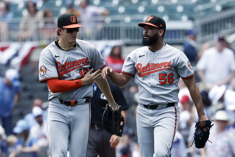 El primera base Coby May y el pitcher Seranthony Domínguez de los Orioles de Baltimore celebran tras la victoria ante los Bravos de Atlanta el domingo 6 de julio del 2025. (AP Foto/Butch Dill)