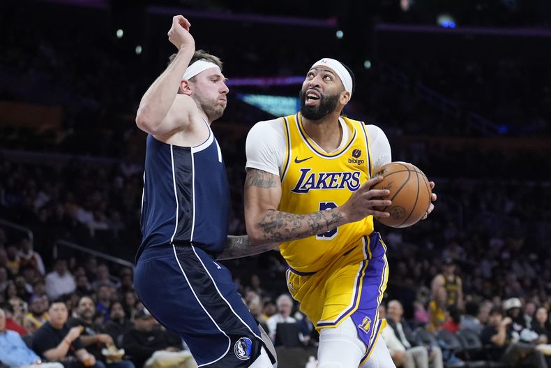 Anthony Davis, derecha, de los Lakers de Los Ángeles, es marcado por Luka Doncic, de los Mavericks de Dallas, durante la segunda mitad del juego de baloncesto de la NBA, el miércoles 17 de enero de 2024, en Los Ángeles. (AP Foto/Marcio Jose Sanchez)