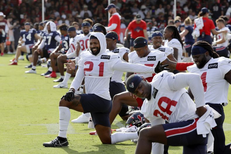 En foto del domingo 30 de julio del 2023, jugadores de los Texans de Houston realizan estiramientos antes del campamento de entrenamiento abierto al público. (AP Foto/Michael Wyke)