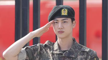 Jin, miembro de la banda de K-pop BTS, saluda después de concluir su servicio militar obligatorio afuera de una base militar en Yeoncheon, Corea del Sur, el miércoles 12 de junio de 2024. (Im Byung-shik/Yonhap vía AP)