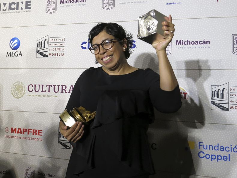 La directora mexico-salvadoreña Tatiana Huezo posa con los premios de mejor largometraje documental mexicano de una directora mujer y mejor largometraje documental por El eco en el Festival Internacional de Cine de Morelia, el viernes 27 de octubre de 2023, en Morelia, México. (Foto AP/Berenice Bautista)