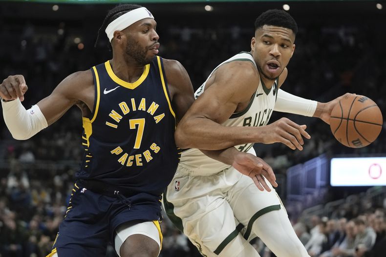 Giannis Antetokounmpo, de los Bucks de Milwaukee, elude a Buddy Hield, de los Pacers de Indiana, en el partido del miércoles 13 de diciembre de 2023 (AP Foto/Morry Gash)