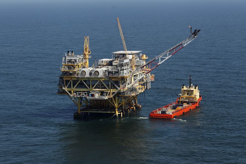 ARCHIVO - Esta foto de archivo del 10 de abril de 2011, muestra una plataforma y un buque de suministro en el Golfo de México, frente a la costa de Luisiana. El gobierno del presidente Joe Biden propuso el viernes hasta tres ventas de arrendamientos financieros de petróleo y gas en el Golfo de México, mientras intenta hacer malabares entre las empresas energéticas que quieren aumentar la producción de petróleo y gas y los activistas ecologistas que quieren que Biden detenga las nuevas perforaciones en alta mar en la lucha contra el cambio climático. (AP Foto/Gerald Herbert, Archivo)