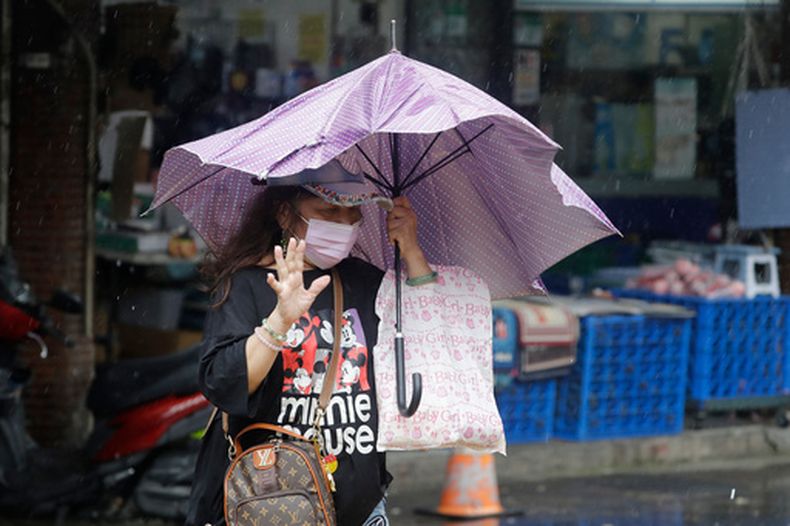 Una mujer lidia con los vientos generados por el tifón Champi, el viernes 23 de octubre de 2026, en Taipéi, Taiwán. (AP Foto/ Chiang Ying-ying)