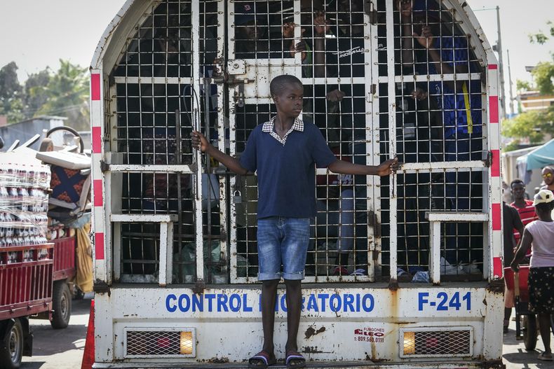 Un niño viaja de pie en la parte trasera de un camión que contiene a haitianos detenidos por las autoridades migratorias dominicanas, el viernes 17 de mayo de 2024, en Dajabón, República Dominicana. (AP Foto/Matías Delacroix)