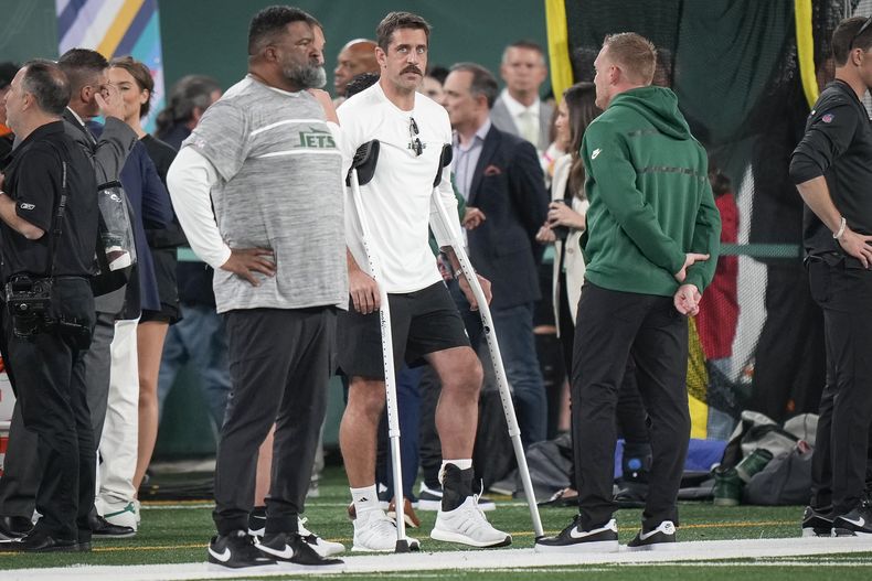 Aaron Rodgers, quarterback de los Jets de Nueva York, se apoya en sus muletas antes de ver el partido ante los Chiefs de Kansas City, el domingo 1 de octubre de 2023 (AP Foto/Bryan Woolston)