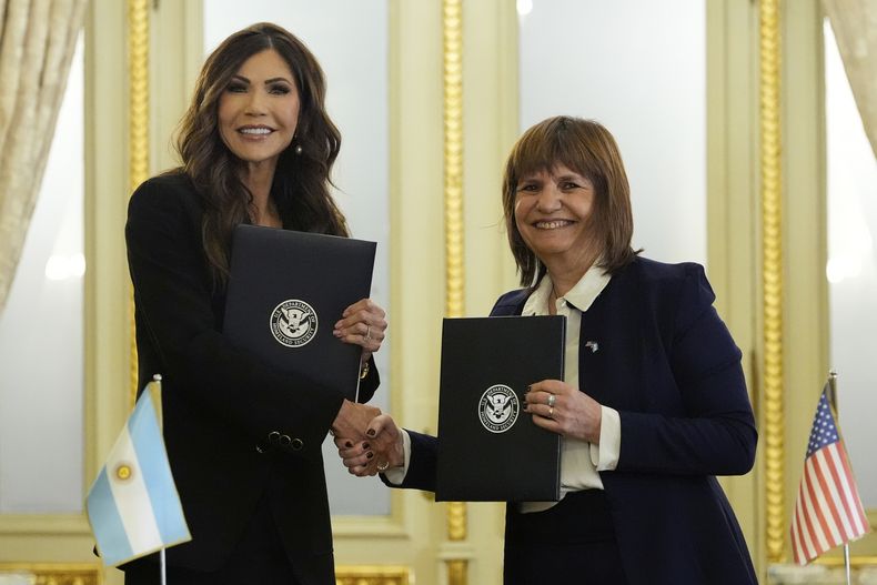 La secretaria de Seguridad Nacional de Estados Unidos, Kristi Noem, a la izquierda, y la ministra de Seguridad de Argentina, Patricia Bullrich, se estrechan la mano ante la cámara mientras mantienen acuerdos bilaterales en la casa presidencial en Buenos Aires, Argentina, el lunes 28 de julio de 2025. (AP Foto/Alex Brandon, Pool)