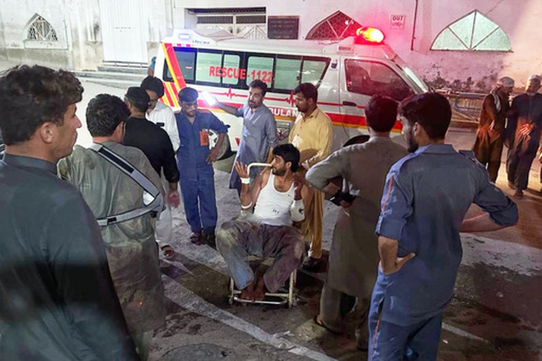 Varias personas trasladan a un hombre, herido en un ataque insurgente a un puesto de la policía en el distrito de Hangu, a su llegada a un hospital en Peshawar, Pakistán, el 30 de julio de 2026. (AP Foto/Arif Khan)