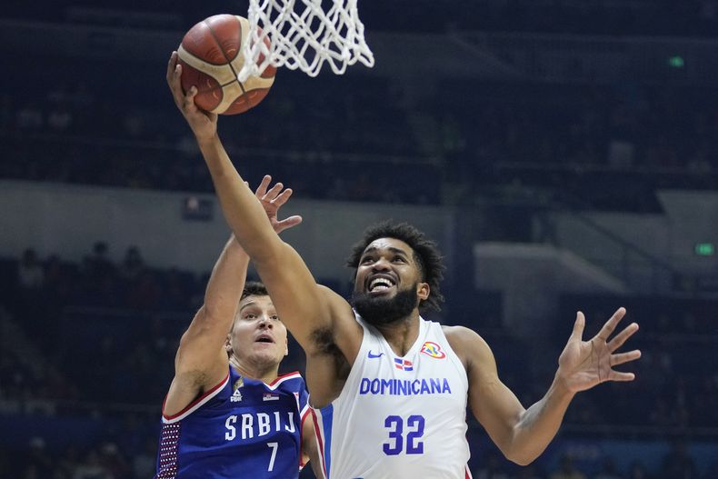 ARCHIVO - El alero dominicano Karl-Anthony Towns busca encestar delante del base serbio Bogdan Bogdanovic, durante un partido del Mundial en Manila, el domingo 3 de septiembre de 2023. (AP Foto/Aaron Favila, archivo)