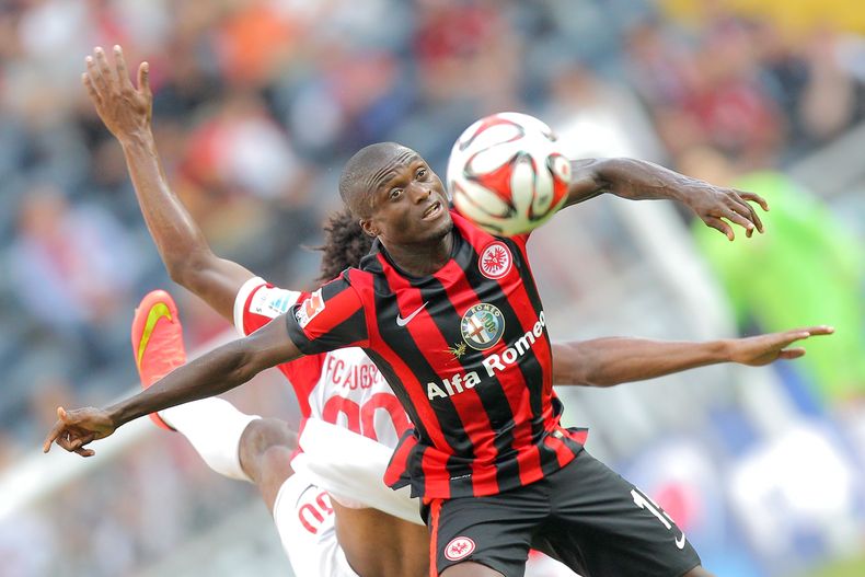 El jugador de Eintracht Frankfurt Constant Djakpa , frente, disputa el bal[o con Cauby, de Augsburgo, en un encuentro de la Bindesliga en Francfort el 14 de septiembre del 2014. (AP Foto/dpa, Fredrik von Erichsen)