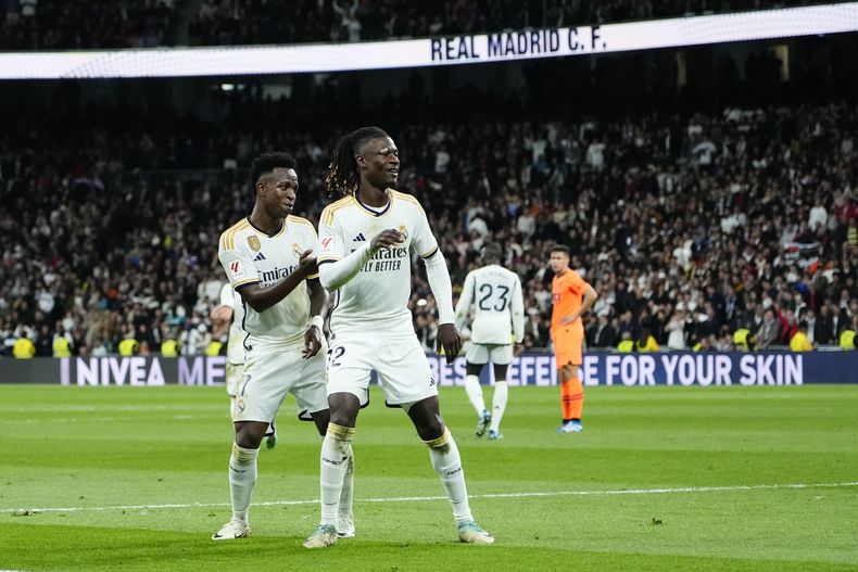 El brasileño Vinícius Júnior (izquierda) festeja con Eduardo Camavigna, su compañero del Real Madrid, luego de anotar el tercer tanto de su equipo ante el Valencia, en un partido de La Liga española, el sábado 11 de noviembre de 2023 (AP Foto/Jose Breton)