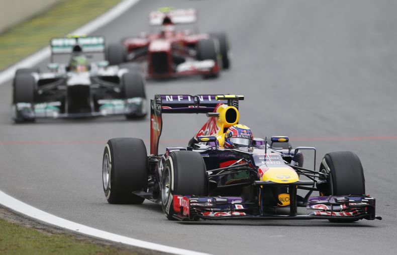 El piloto de Red Bull, Mark Webber, al frente, maneja delante del piloto de Mercedes, Lewis Hamilton, y el de Ferrari, Felipe Massa en el GP de Brasil el domingo, 24 de noviembre de 2013, en Sao Paulo. (AP Photo/Felipe Dana)