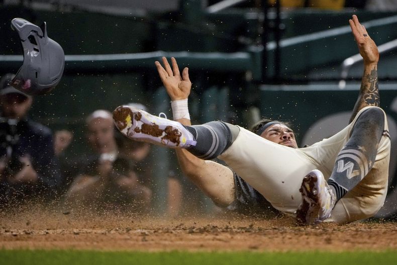 Michael Chavis, de los Nacionales de Washington, anota en un lanzamiento descontrolado para poner fin en el undécimo inning al juego del sábado 9 de septiembre de 2023, ante los Nacionales de Washington (AP Foto/Andrew Harnik)