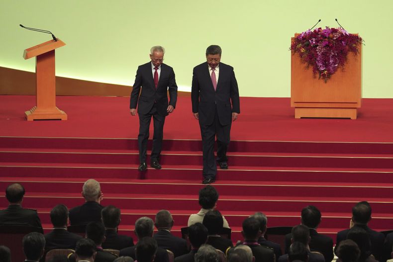 El presidente chino, Xi Jinping, derecha, y el recién investido jefe ejecutivo de Macao, Sam Hou Fai, abandonan el escenario tras la ceremonia de investidura en el marco del 25º aniversario del traspaso de Macao de Portugal a China, en Macao, el viernes 20 de diciembre de 2024. (Justin Chan/Pool foto via AP)