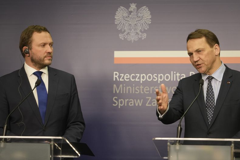 El ministro de Relaciones Exteriores de Polonia Radek Sikorski, derecha, y su homólogo de Estonia Margus Tsahkna, izquierda, hablan con reporteros después de sus conversaciones sobre seguridad regional y el apoyo continuo a Ucrania en su lucha contra la invasión rusa, en el Ministerio de Relaciones Exteriores en Varsovia, Polonia, el 14 de febrero de 2024. (AP Foto/Czarek Sokolowski)