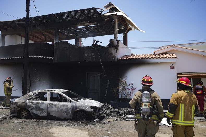 Los bomberos trabajan en el lugar donde una avioneta se estrelló contra una residencia en el distrito de San Bartolo, en Lima, Perú, el sábado 22 de febrero de 2025. Según la policía, el piloto y el copiloto fueron rescatados y trasladados al hospital más cercano. No se reportaron otras lesiones. (Foto AP/Guadalupe Pardo)
