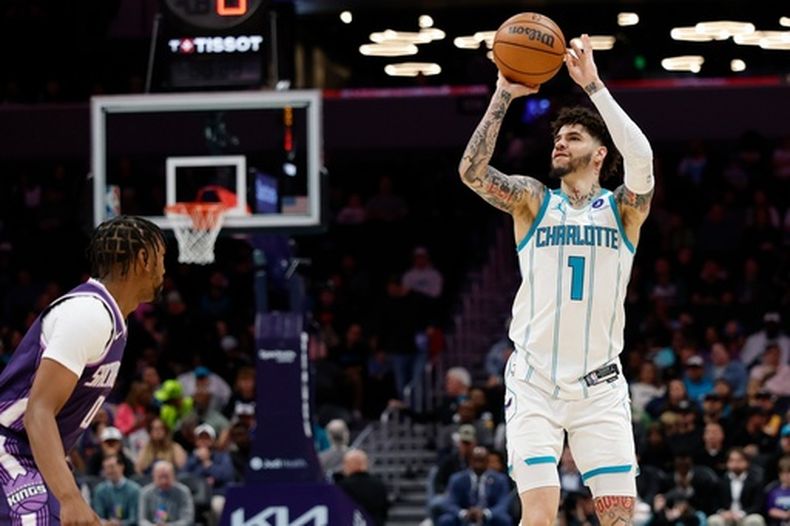 El base de los Hornets de Charlotte, LaMelo Ball (1), lanza ante la defensa del base de los Kings de Sacramento, Malik Monk, durante la primera mitad de un juego de baloncesto de la NBA en Charlotte, Carolina del Norte, el martes 24 de marzo de 2026. (Foto AP/Nell Redmond)