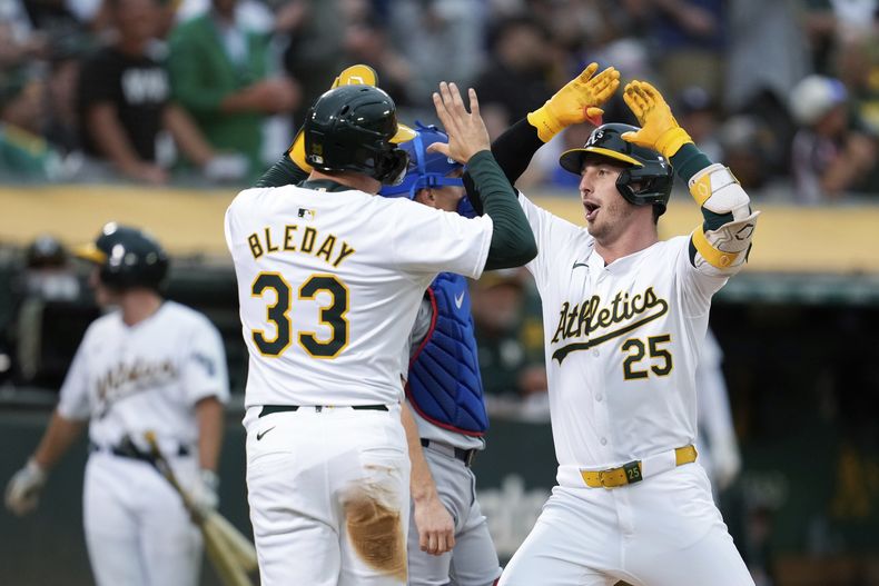 Brent Rooker, derecha, de los Atléticos de Oakland, celebra con JJ Bleday (33) después de batear jonrón de dos carreras contra los Dodgers de Los Ángeles durante la quinta entrada del juego de béisbol del viernes 2 de agosto de 2024, en Oakland, California. (AP Foto/Godofredo A. Vásquez)