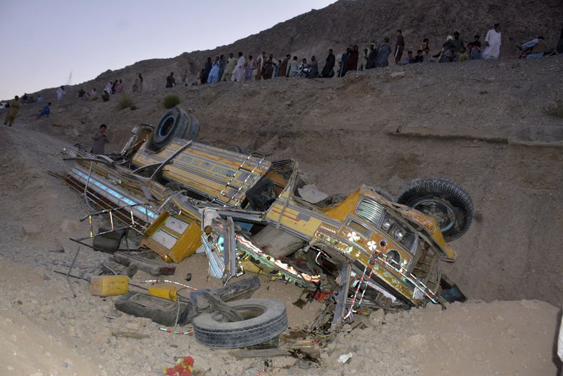 Residentes locales se congregan junto a los restos de un autobús que cayó en un barranco cerca de Quetta, capital de la provincia de Baluchistán, Pakistán, el jueves 3 de octubre de 2024. (AP Foto/Arshad Butt)