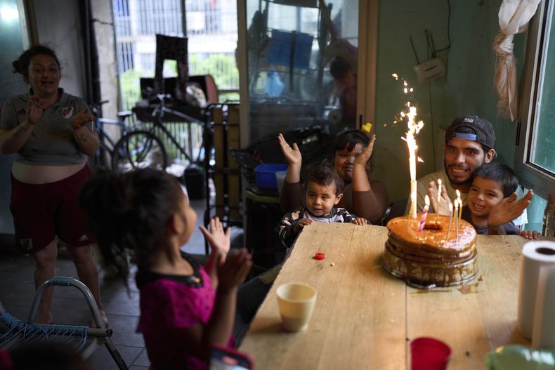 Elías Fernández, a la derecha, celebra su 28 cumpleaños en la casa de un amigo, donde se aloja con su familia, en Buenos Aires, Argentina, el sábado 2 de marzo de 2025. (AP Foto/Rodrigo Abd)