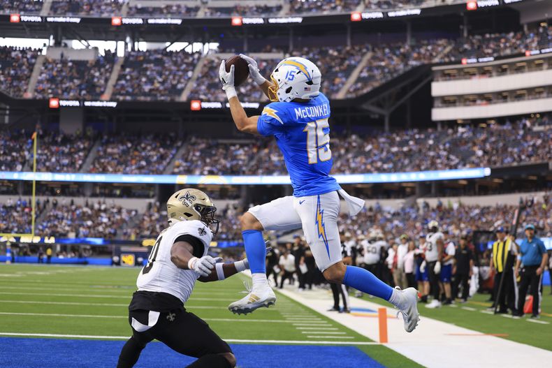 El receptor de los Chargers de Los Ángeles Ladd McConkey salta para atrapar el balón para touchdown frente al safety de los Saints de Nueva Orleans Ugo Amadi en el encuentro del domingo 27 de octubre del 2024. (AP Foto/Ryan Sun)