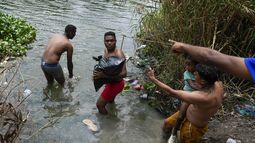 Migrantes cruzan el río Bravo (Rio Grande en inglés) hacia el lado estadounidense el jueves 11 de mayo de 2023, desde Matamoros, México. Los migrantes se apresuraban a cruzar la frontera el jueves con la esperanza de ingresar a Estados Unidos horas antes de que se levanten las restricciones al asilo relacionadas con la pandemia de COVID-19. (AP Foto/Fernando Llano)