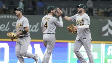 Ramon Laureano, Kevin Smith y Seth Brown, de los Atléticos de Oakland, celebran después de derrotar a los Cerveceros de Milwaukee el juego de béisbol el domingo 11 de junio de 2023, en Milwaukee. Los Atléticos ganaron 8-6 y barrieron la serie. (AP Foto/Morry Gash)