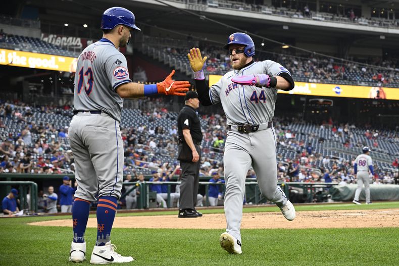 Harrison Bader (44), de los Mets de Nueva York, es recibido por Luis Torrens (13) después de anotar con un sencillo de José Iglesias durante la sexta entrada de un juego de béisbol contra los Nacionales de Washington, el miércoles 5 de junio de 2024, en Washington. (AP Foto/Nick Wass)