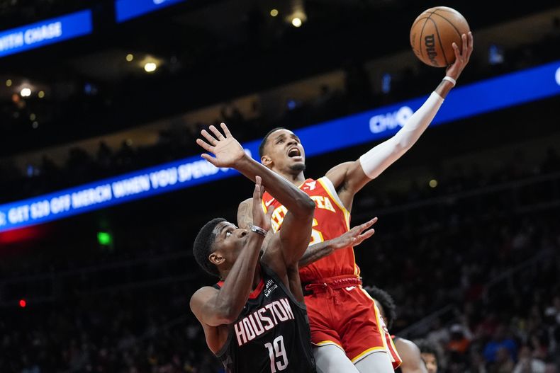 Dejounte Murray, de los Hawks de Atlanta, encesta frente a Nate Williams, de los Rockets de Houston, en el duelo del sábado 10 de febrero de 2024 (AP Foto/John Bazemore)
