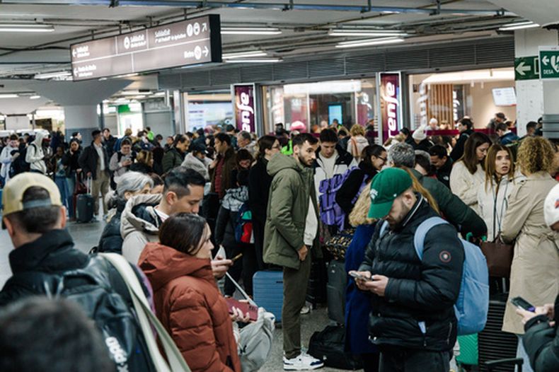 Pasajeros esperan en el vestíbulo de la estación de trenes de Madrid, el domingo 18 de enero de 2026, tras el anuncio de la suspensión del servicio debido al descarrilamiento de dos trenes en Córdoba. (Carlos Luján/Europa Press vía AP)