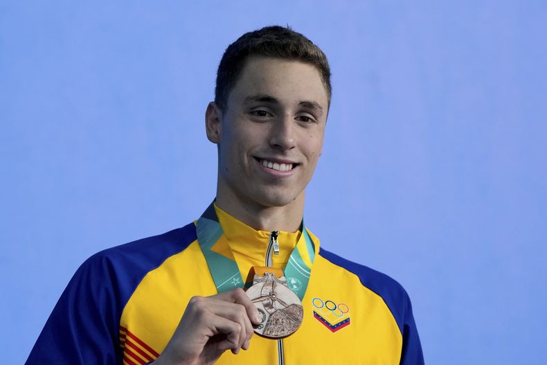 El venezolano Alfonso Mestre posa con su medalla de bronce en el podio de los 1.500 metros libre de la natación de los Juegos Panamericanos en Santiago, Chile, el miércoles, 25 de octubre de 2023. (AP Foto/Natacha Pisarenko)
