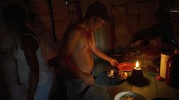 Edinector Vázquez se prepara para cenar en su casa iluminada por una lámpara de gas durante un apagón de luz en Minas, en la provincia de La Habana, Cuba, el lunes 26 de mayo de 2025. (AP Foto/Ramón Espinosa)