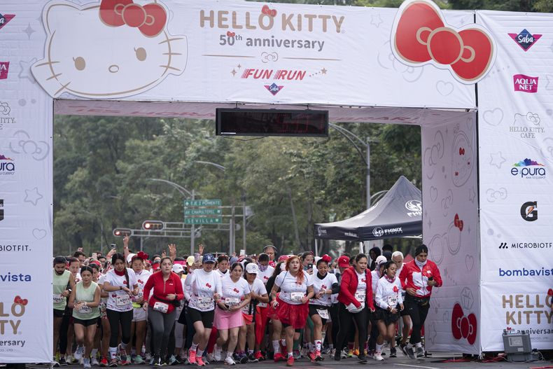 Fans del personaje japonés Hello Kitty salen a correr al inicio de una carrera como parte de las celebraciones por el 50 aniversario del personaje, en la Ciudad de México, el domingo 13 de octubre de 2024. (Foto AP/Aurea Del Rosario)