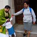El padre Carlos Reyes saluda a los feligreses tras celebrar misa en el Santuario del Sagrado Corazón, una iglesia católica, el domingo 12 de octubre de 2025, en Washington. (AP Foto/Luis Andrés Henao)