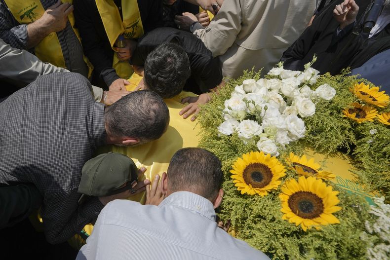 Dolientes besan el féretro del alto comandante de Hezbollah Taleb Sami Abdullah, de 55 años, conocido dentro de Hezbollah como Hajj Abu Taleb, que fue asesinado a última hora del martes por un ataque israelí en el sur de Líbano, durante su procesión fúnebre en los suburbios del sur de Beirut, Líbano, miércoles 12 de junio de 2024. (AP Foto/Bilal Hussein)
